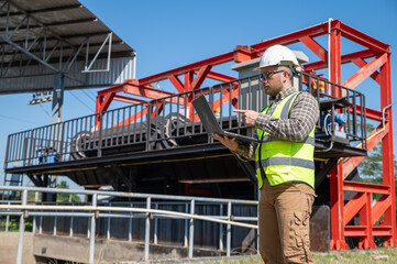 Industrial specialist using laptop to analyze high-value operational data and ensure optimal machinery performance