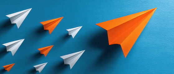 Orange paper airplane leading white paper airplane fleet business concept leader innovation teamwork inspiring flight