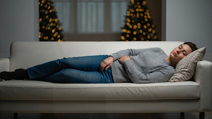 Woman resting on couch with pain in winter living room decor  