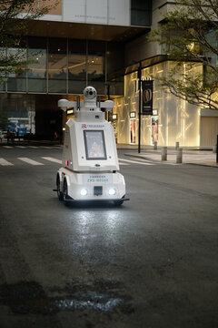 Shenzhen,China - December 2, 2025:Autonomous police security robot patrolling modern urban street. Advanced robotic law enforcement technology ensuring public safety in smart city environment.