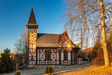 Historic church with timber framing at sunrise in a scenic view. The Stary Smokovec, settlement and the administrative center of the High Tatras National Park in Slovakia, Europe.