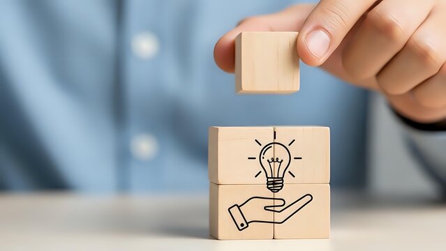 Businessman hand placing wooden cube with lightbulb and hand icon representing innovation and creative business solutions concept. - Powered by Adobe