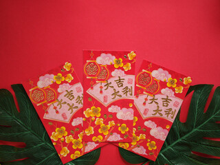 Chinese New Year Red Envelopes (Ang Pao) with Golden Calligraphy and Green Leaves on Red. Chinese new year decoration. 