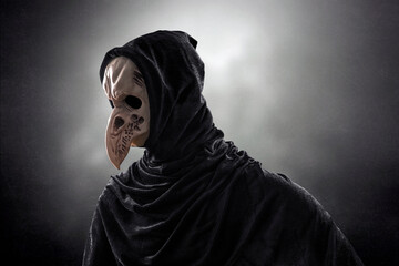 Creepy figure with animal bird skull over dark misty background