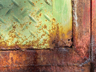 Rust  corrosion on a steel door  . Advanced rust corrosion on a steel door surface  . close up of rust - induced corrosion and material degradation on steel  .