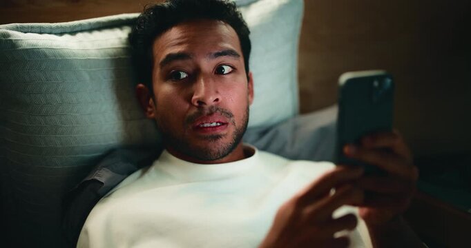 Man, phone and aroused in bed for temptation, self pleasure and masturbation in home. Night, secret and person with smartphone for pornography, addiction and sneaky activity in bedroom of apartment