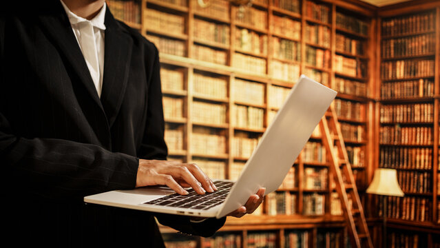 Professional woman using laptop inside library, digital resource organization, user assistance, literacy development, essential role librarians play in modern knowledge and data environments.