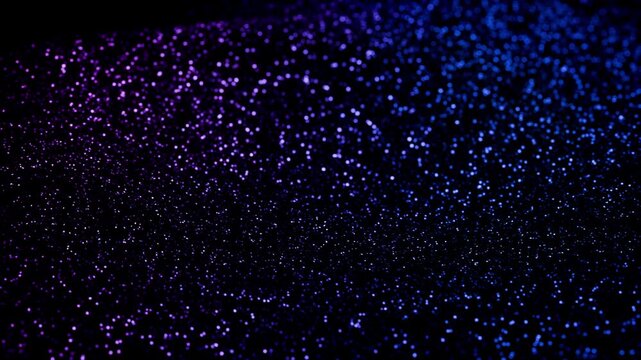 Glittering waves background with flowing vast field of shimmering purple and blue light particles. Abstract glamour animation with soft bokeh effect for events , festivals and celebrations. 4K 60 fps
