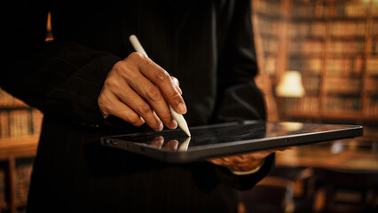 Professional woman holding digital tablet inside library, representing information management, cataloging, evolving responsibilities of modern librarians in physical, digital knowledge environments.