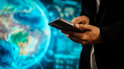 Business woman holding smartphone in front of futuristic digital interface, global communication, technology networking, data connectivity, mobile interaction, high-tech environment.