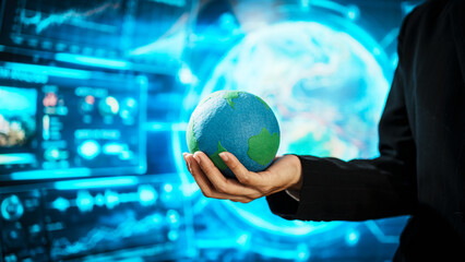 Business professional holding small Earth model before futuristic digital interface, global responsibility,environmental awareness,world protection, sustainability, modern international collaboration