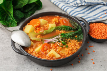 Tasty lentil soup served on grey table, closeup