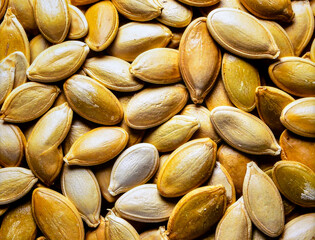 Close up pumpkin seeds surface showing organic plant based food texture