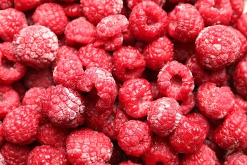 Frozen ripe raspberries as background, top view