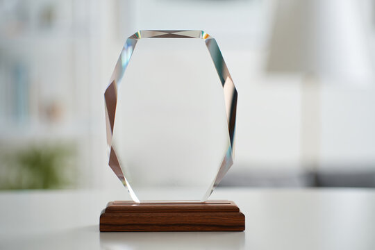 Crystal recognition award on a wooden base displayed on a clean white desk