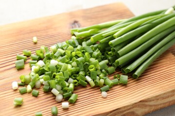 Cut green onions and knife on table, closeup