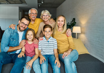 Portrait of a three generation famili, grandparents, parents and children sitting on sofa and...