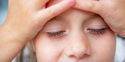 Fototapeta premium crying little girl, holding head, suffering from headache after fall, Overwhelmed elementary school child, looking sad and weak, conveying stress, fatigue, moments hurt, disappointment, overwhelming