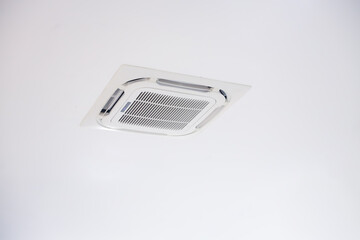 Ceiling-mounted air conditioning vent panel in white modern interior