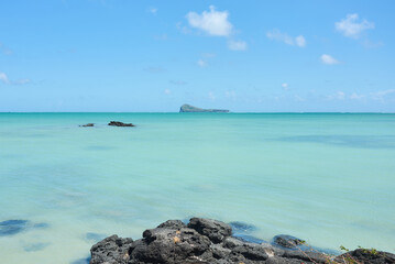 A scenic view of Coin de Mire Island off the northern coast of Mauritius, showcasing its dramatic volcanic cliffs surrounded by deep blue ocean waters, a striking landmark of the island&rsquo;s beauty