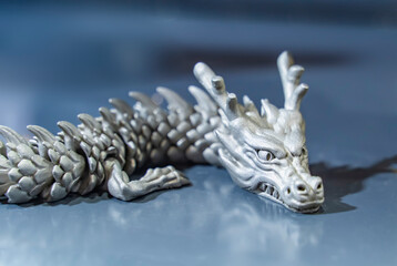 3D printer printing metal dragon head figure close-up.