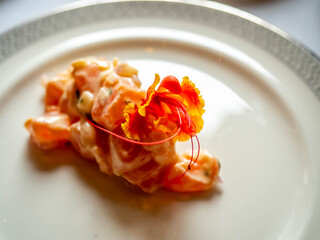 Seafood mixed salad decorated with colorful flower on white dish for appetizer in luxury restaurant