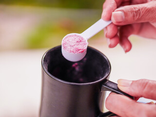 Lifestyle Health care. Hand person scooping collagen powder. Collagen, which contains vitamins, helps nourish, anti age, nutrition and restore the body's deterioration. Healthy snacks morning routine 