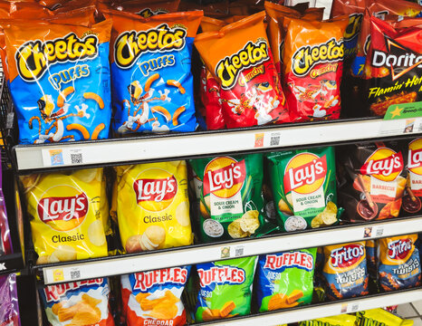 A retail shelf stocked with Frito-Lay chip products, including Cheetos, Lay's,  Ruffles, Doritos, and Fritos varieties on December 8, 2025 in Minnesota, USA. For Editorial Use Only.
