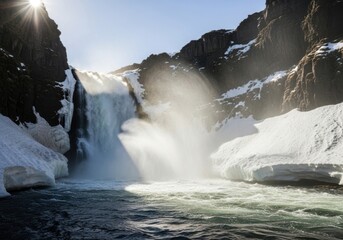 Powerful waterfall in winter landscape with sunburst effect