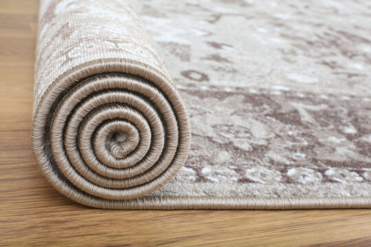 A custom-designed carpet is being laid on the floor, half of it rolled up.