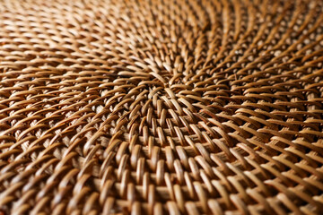 Woven rattan texture forming a natural brown pattern, showing close up details of artisanal craftsmanship and material
