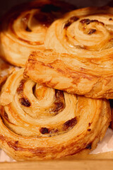 Freshly baked pain aux raisins pastries, a sweet treat and breakfast staple, warm and golden brown from the bakery