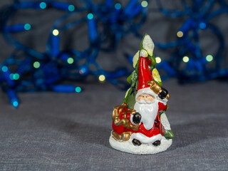 Ceramic Santa Claus with a Christmas tree. Christmas decorations on the table. Festive mood