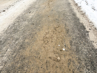 Deicing salt scattered on icy street creating a slippery hazard  