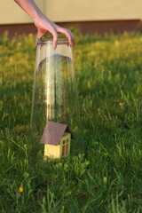 Fototapeta premium Miniature house in a glass dome held by a hand