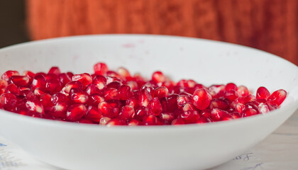 Bright Ruby Red Pomegranate Arils (Seeds) in a White Bowl Promoting antioxidants, superfoods, and fruit-based snacks