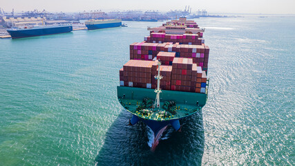A container ship, fully loaded with goods, sails out to sea, delivering products to various locations around the world.