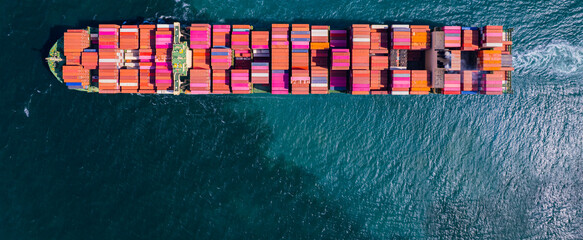 A container ship, fully loaded with goods, sails out to sea, delivering products to various locations around the world.