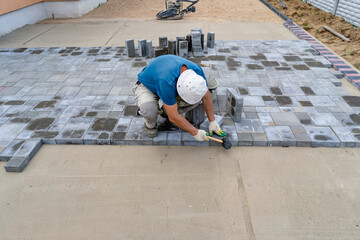 worker lays paving concrete tiles top view