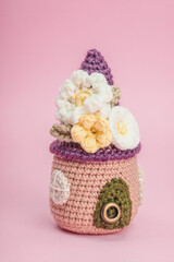 Handmade spring decor concept. Creative crocheting, house figurine, traditional flowers, decoration