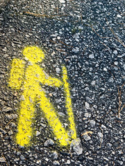 Yellow hiking trail figure marker painted on the ground