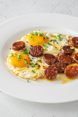 Hearty fried eggs served with caramelized chorizo slices and fresh scallion garnish