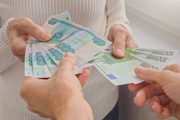 Exchange of rubles for euros. Banknotes in hand.