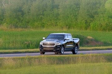 Modern pickup crossing rural farmland at speed