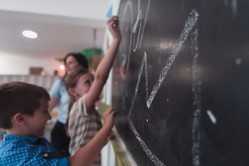 Children write and draw on the blackboard in elementary school while learning the basics of education