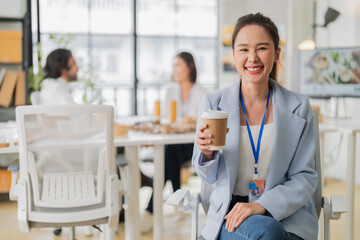 Fototapeta premium portrait captures a smart, confident Asian woman leading an office meeting, brainstorming ESG and upcycled material packaging ideas as a corporate leader