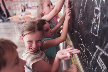 Children write and draw on the blackboard in elementary school while learning the basics of education
