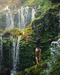 Woman Embracing Nature at Lush Banyu Wana Amertha Waterfalls in Tropical Bali