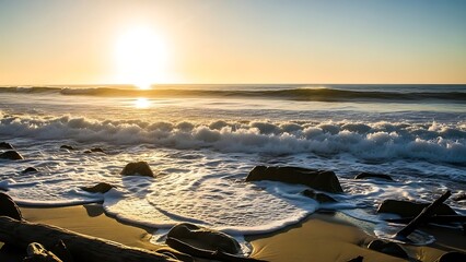 Peaceful beach scene at sunset with waves and rocks on sandy shore