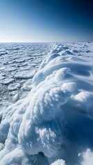 A vast expanse of ice floes under a clear blue sky with a large ridge of ice in the foreground
